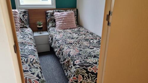 a bed in a small room with a bed sidx sidx sidx at 3 Bed Caravan at Parkdean Resort Southview Skegness on a Fishing Lake in Lincolnshire