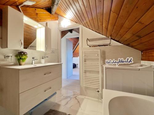 baño con armarios blancos y lavamanos en Casa Max & Lory by Holiday World en Cogoleto