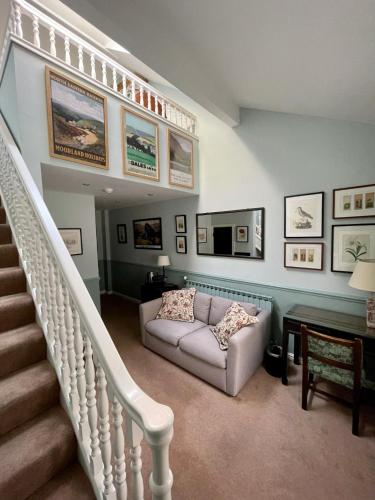 a living room with a staircase and a couch at Holdsworth House Hotel in Halifax