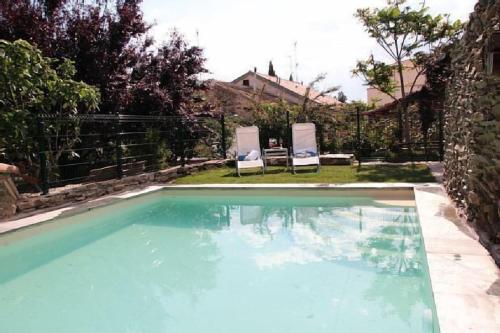 a swimming pool with two lawn chairs at Casa Rural Doña Catalina in Santa María la Real de Nieva