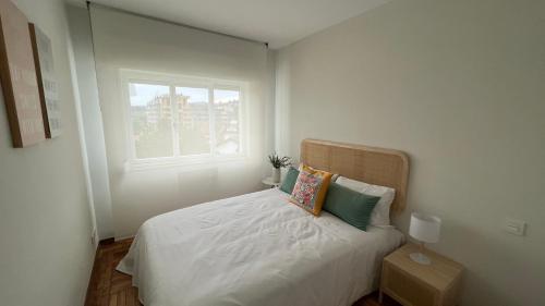 a bedroom with a white bed with a window at Bellavetusta in Oviedo