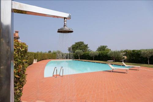 a swimming pool with a water fountain and a chair at 3 Bedroom Villa, Lake Garda in Lazise