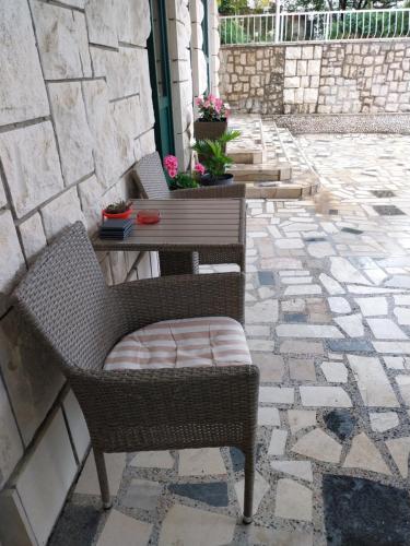 two wicker chairs and a table on a patio at Sobe Kraft 1 in Živogošće