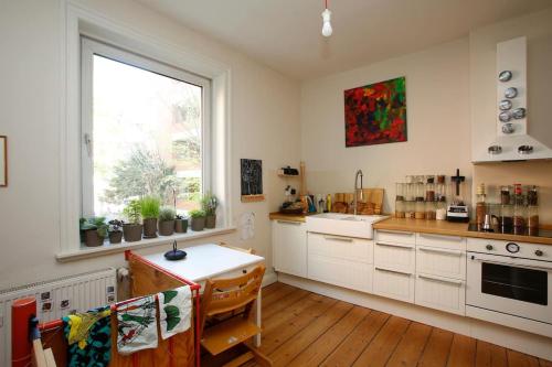 uma cozinha com armários brancos e uma janela em Family Friendly Funhouse Centrally Located in Ottensen em Hamburgo