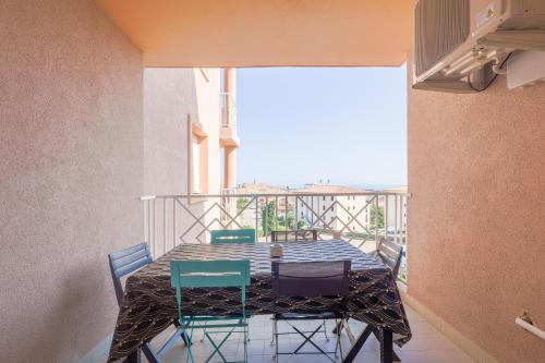 une table et des chaises sur un balcon avec vue dans l'établissement Fornole - Appt vue mer pour 6 voyageurs, à LʼÎle-Rousse