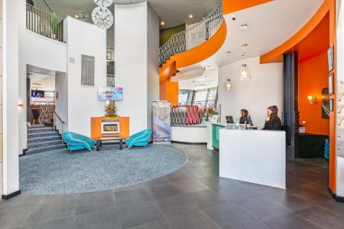 a lobby with orange and white walls and people at a counter at The Glasshouse in Sligo