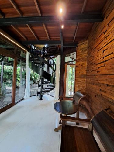 a room with a wooden wall and a spiral staircase at Green Tree House Villa Ubud in Ubud