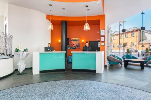 an office with orange walls and a lobby with chairs at The Glasshouse in Sligo