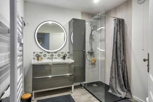 a bathroom with a sink and a mirror at La Quinardais - Charmante maison avec terrasse in Saint-Samson-sur-Rance