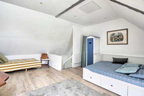 a bedroom with two beds and a chair at La Quinardais - Charmante maison avec terrasse in Saint-Samson-sur-Rance