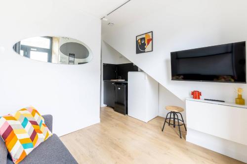 a living room with a couch and a tv at LIK APPARTS MABILAY in Rennes