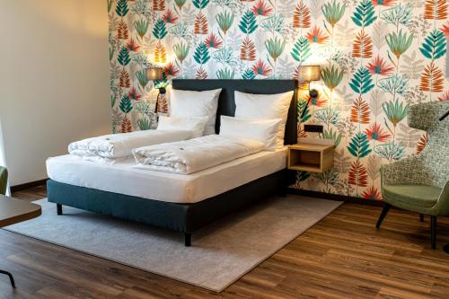 Bett in einem Zimmer mit Blumentapete in der Unterkunft Lieb&Wert in Raesfeld