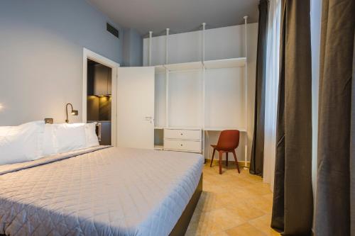 sypialnia z łóżkiem i biurkiem z krzesłem w obiekcie Residence 9 Line w mieście Milano Marittima