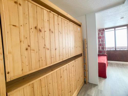 une chambre avec des murs lambrissés et un lit rouge dans l'établissement Studio lumineux 4 pers · Balcon · Proche remontées · Ski aux pieds · Animaux acceptés - FR-1-502-309, à Tignes