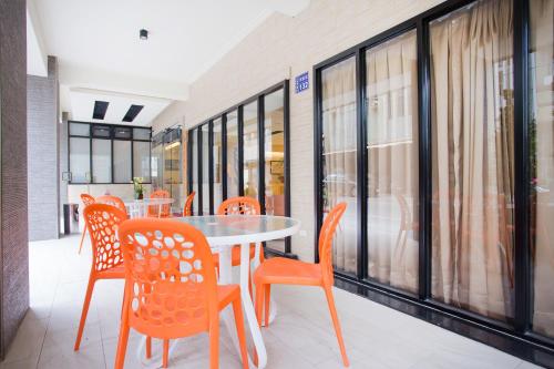 uma sala de jantar com cadeiras laranja e uma mesa em Yung An Business Hotel em Dounan