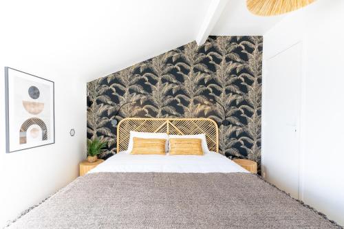 a bedroom with a large bed with a black and white wallpaper at LIK APPARTS MABILAY in Rennes