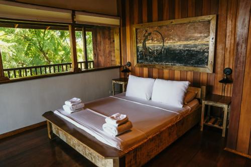een slaapkamer met een bed met twee dozen erop bij Bambuda Lodge in Bocas del Toro
