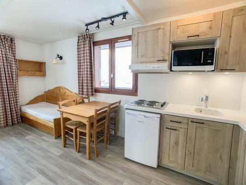 - une petite cuisine avec une table et un lit dans une chambre dans l'établissement Appartement 6 pers. à Tignes Val Claret - Accès direct aux pistes, balcon, animaux acceptés - FR-1-502-289, à Tignes