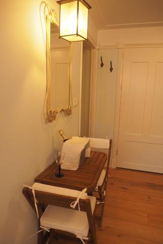 a room with a table and a mirror on the wall at B&B Bureau Warmoesstraat in Den Burg