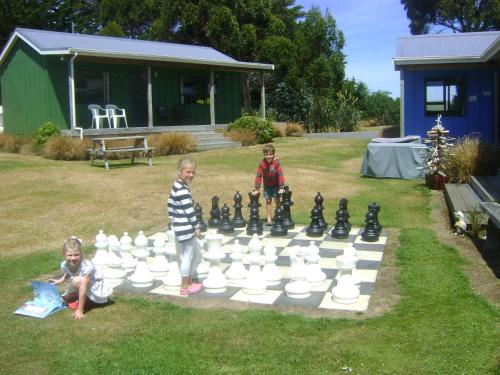 two children playing chess on a giant chess board at Catlins Newhaven Holiday Park in Owaka