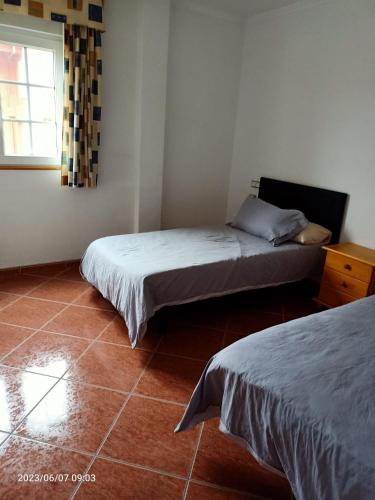 a room with two beds and a window in it at PISO HARLEY in Camariñas