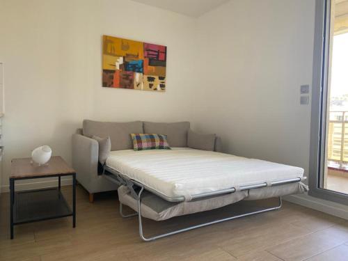 uma cama no canto de um quarto com uma mesa em Sublime Appart- Vue Mer-Prado13008- Proche Plage Vélodrome em Marselha