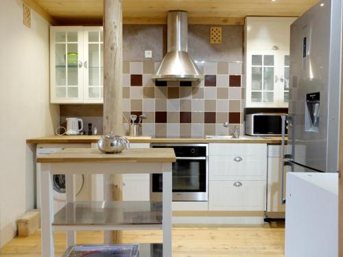 une cuisine avec des armoires blanches et un réfrigérateur en acier inoxydable dans l'établissement Appartement rénové 8p à Tignes · Proche pistes et commerces · Balcon · Sud · Animaux acceptés - FR-1-502-508, à Tignes