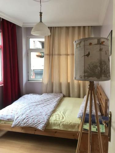 a bedroom with a bed with a lamp and a window at Bright apartment in Beşiktaş / Abbasağa in Istanbul