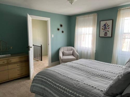 a bedroom with a large bed and a chair at Spacious & Peaceful Home in the heart of Sheboygan in Sheboygan