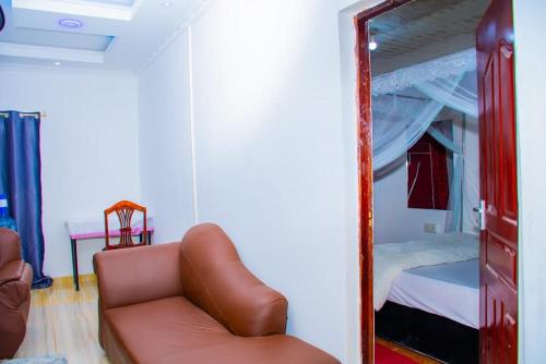 espejo en una habitación con sofá y cama en CRYSTAL HOMES Air BnB, en Mumias