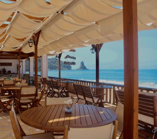a table and chairs with a view of the ocean at Elena's Seaside Apartments & Studios in Agios Gordios