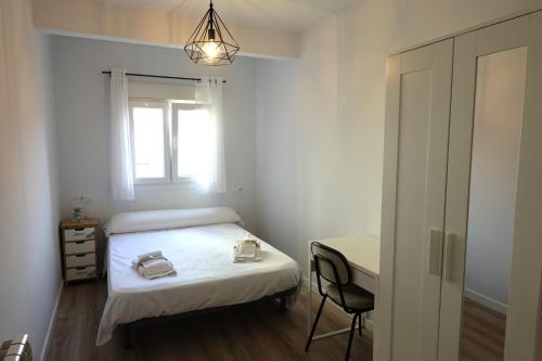 a bedroom with a bed and a desk and a window at Vacare centro de Santander in Santander