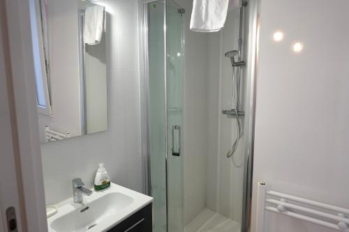 a white bathroom with a shower and a sink at Vacare centro de Santander in Santander