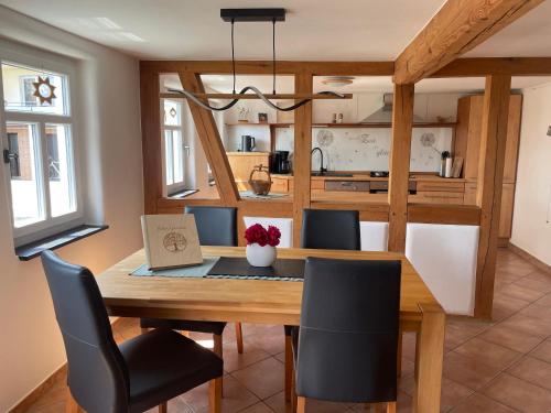 uma sala de jantar e cozinha com mesa e cadeiras de madeira em Ferienhaus Beller Gehaichnis em Bell