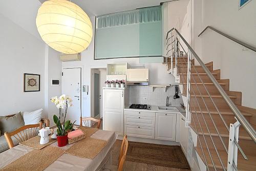 eine Küche und ein Esszimmer mit einem Tisch, einer Küche und einer Treppe in der Unterkunft Conero Casa - Marcelli di Numana in Via Litoranea 101 in Marcelli