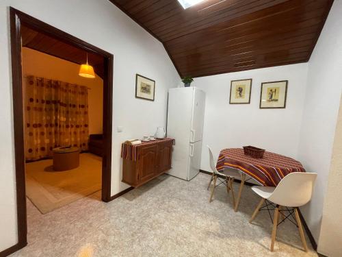 a dining room with a table and a refrigerator at Pereira Place - Cottage in São Vicente