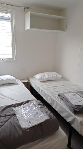 dos camas sentadas una al lado de la otra en una habitación en Mobile home, en La Turballe