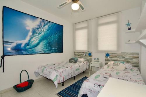 1 dormitorio con 2 camas y una pantalla grande en Tantulia Magallanes 32 Apartamento 3hab en tenerife, en El Médano