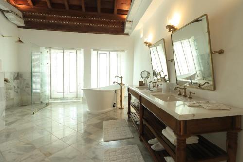 a bathroom with a tub and a sink and a mirror at Casa Pestagua Relais Châteaux in Cartagena de Indias