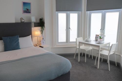 a bedroom with a bed and a table and chairs at Pier12 in Eastbourne