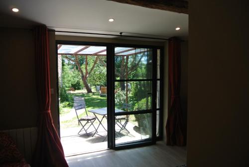 a sliding glass door leading to a patio with a table at les epis du vent in Adilly
