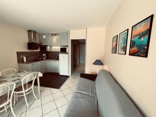 un salon avec un canapé et une cuisine dans l'établissement Standing et océan à 50m, appartement de l'oasis, à Saint-Jean-de-Monts