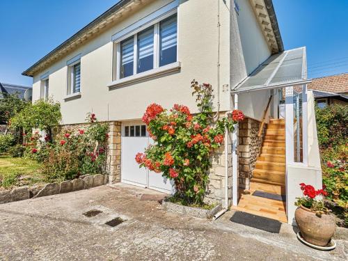 a house with a white door and red flowers at Holiday Home Janomaine by Interhome in Cabourg