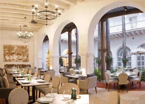 een restaurant met tafels en stoelen en grote ramen bij Casa Pestagua Relais Châteaux in Cartagena