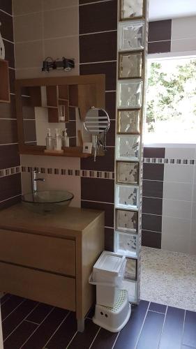 La salle de bains est pourvue de toilettes et d'une étagère avec de la vaisselle. dans l'établissement Maison piscine, à Carcans