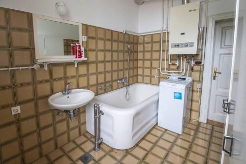 a bathroom with a bath tub and a sink at Socialist Experience in the City Center in Ljubljana