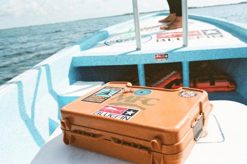 an orange suitcase sitting on the back of a boat at Grand Slam Fishing Lodge Tulum in Punta Allen