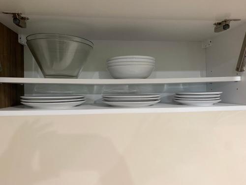 a white shelf with bowls and plates on it at Posestvo Tmžek in Bovec