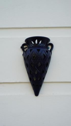 a black vase is hanging on a wall at riad casa bahia asilah in Asilah