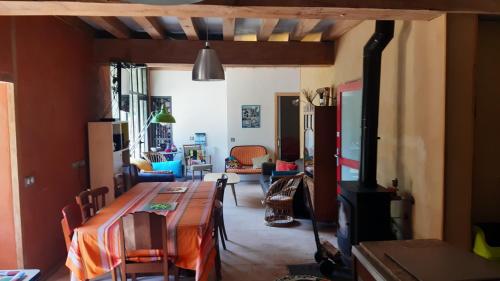 un salon avec une table et une cheminée dans l'établissement la grange, à Pouligny-Saint-Pierre